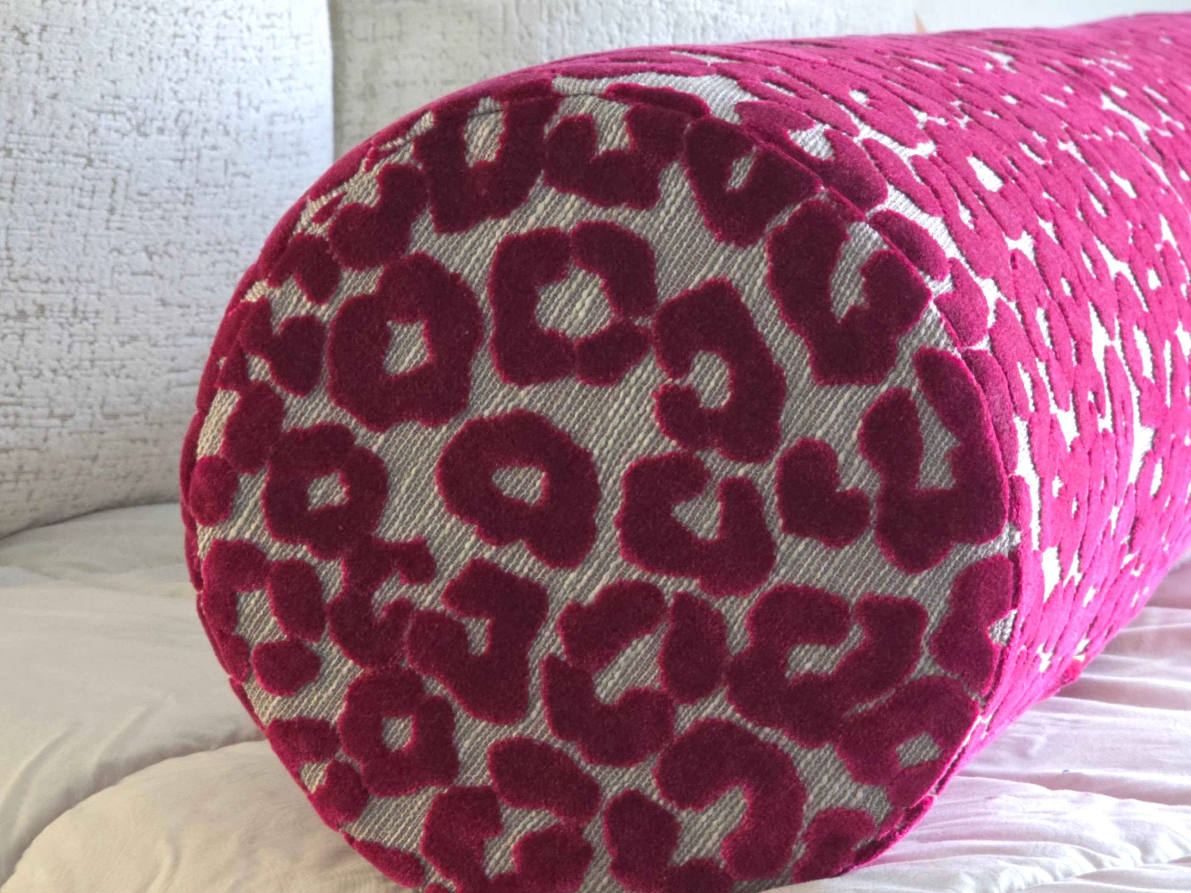 Cylindrical pillow with pink leopard print pattern on a neutral background