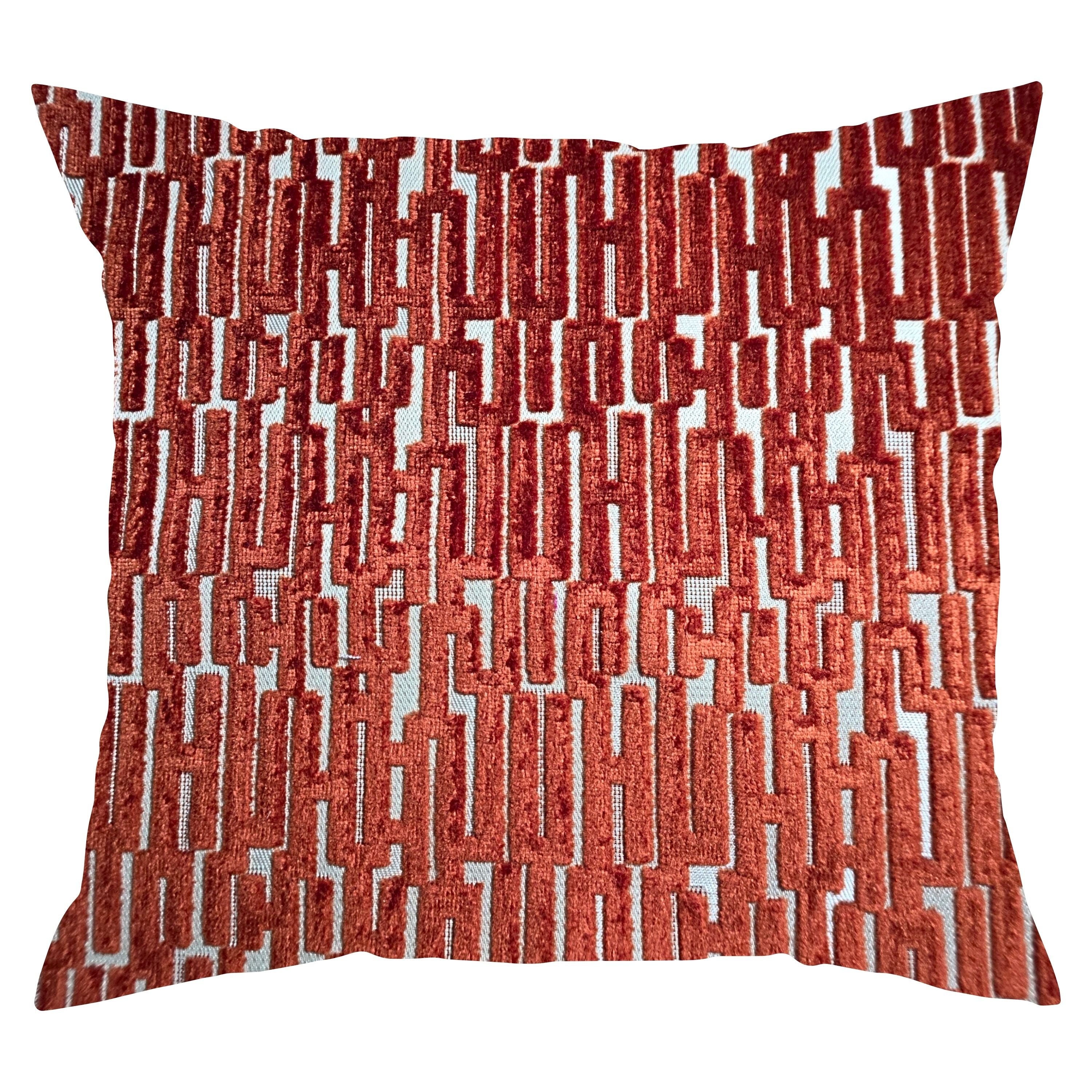 Decorative pillow with a geometric red pattern on a white background