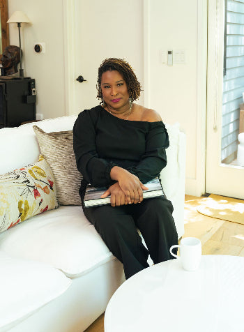 Makena Decor founder sitting on white sofa