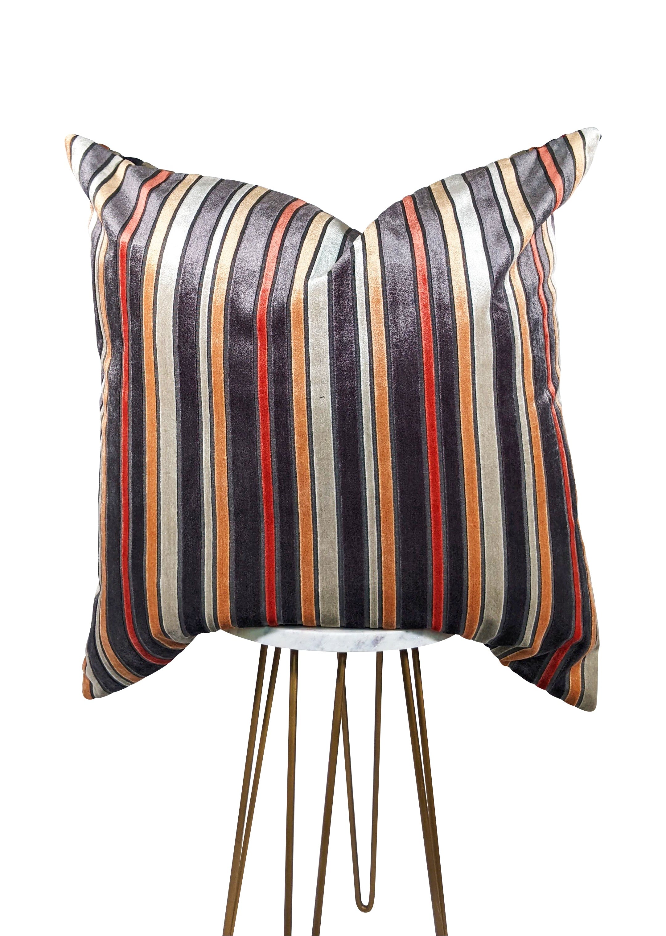 A square-shaped throw pillow with a pattern of burnt orange and gray stripes on a gray background, showcasing a hidden zipper closure.