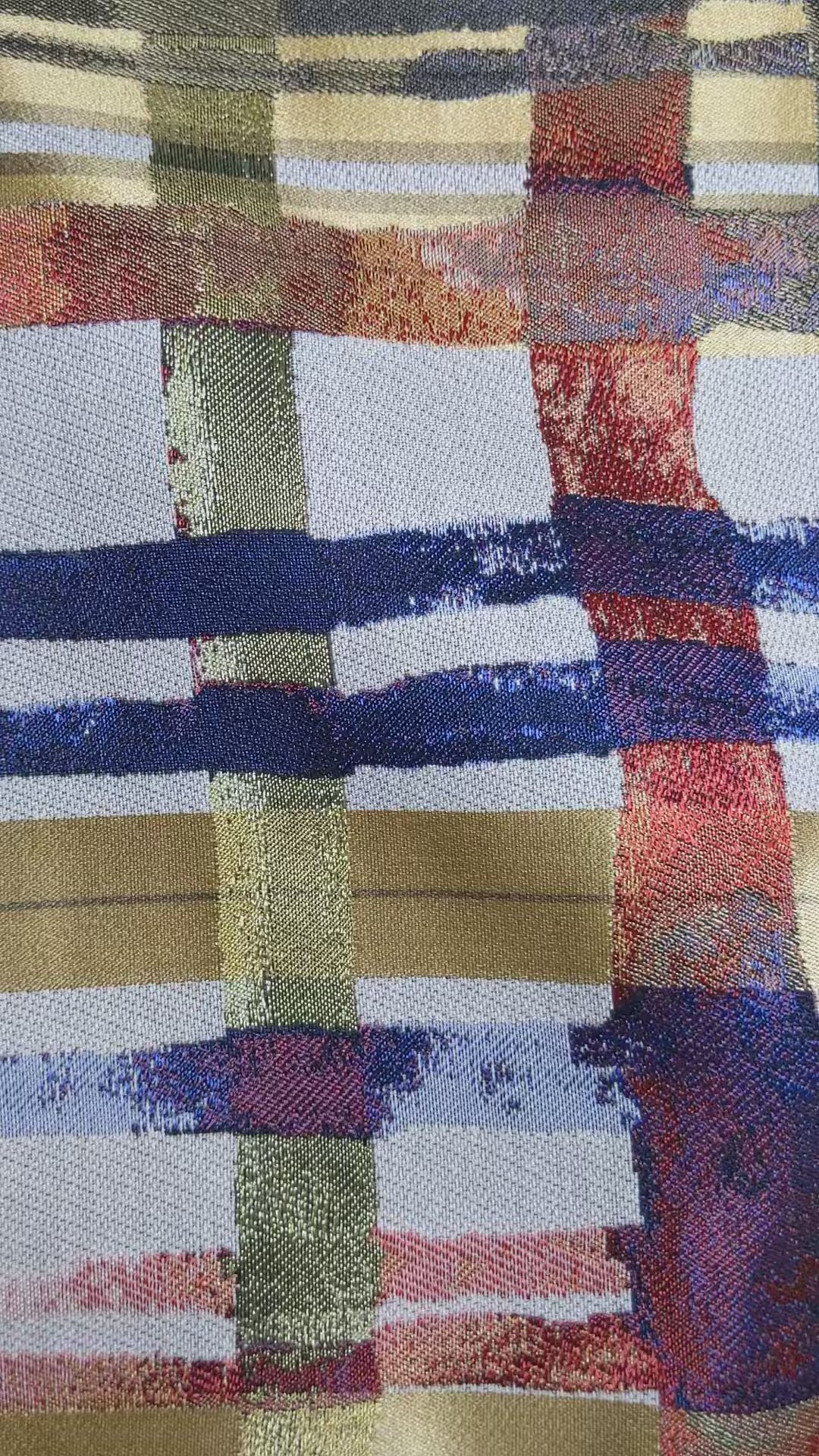 Multicolored throw pillow with checkered lines on a cream background