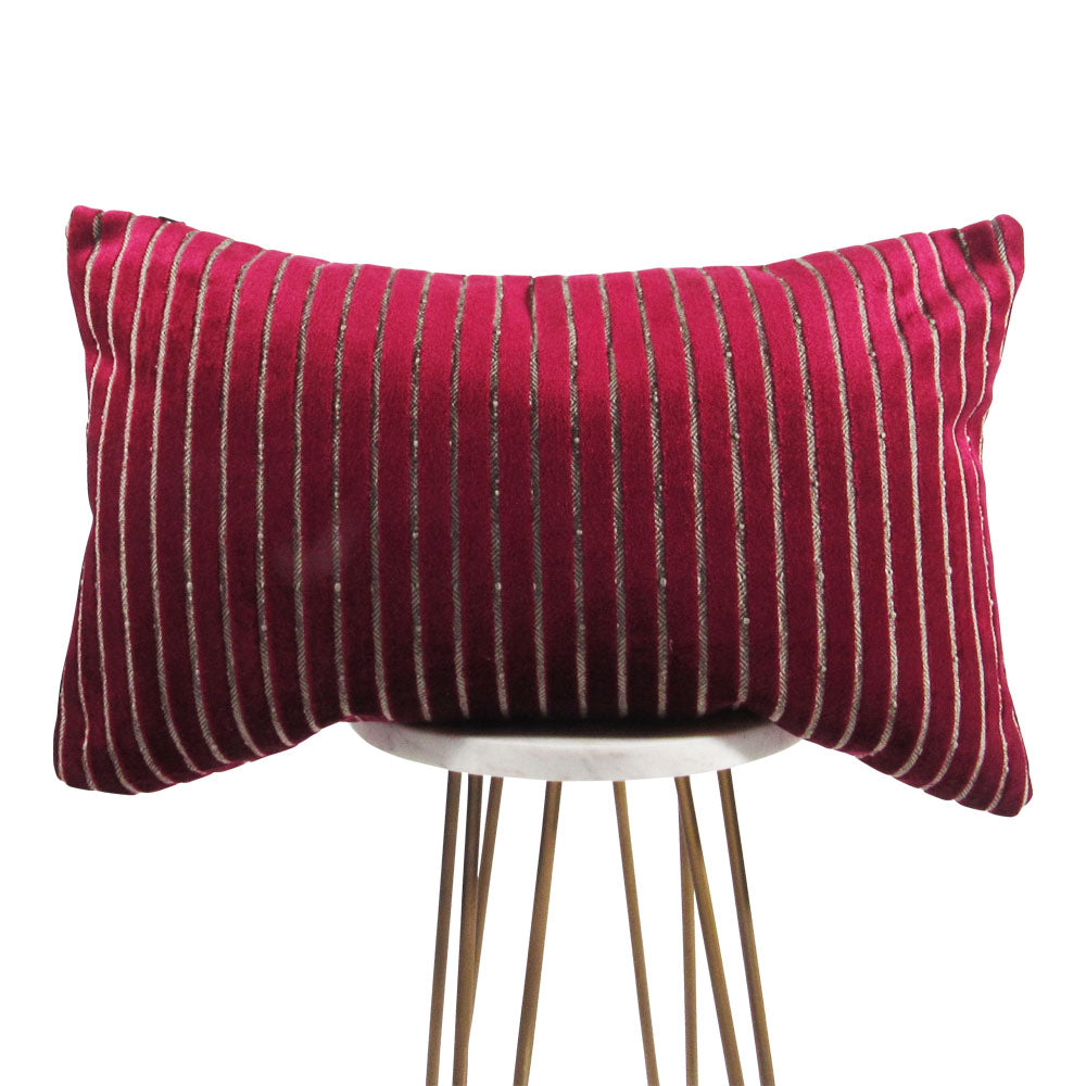 shiny fuchsia 13x21 rectangle throw pillow with indented lines throughout, displayed on small white table.