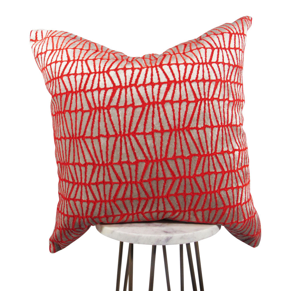 bright orange and silver 20x20 throw pillow with slanted lines, displayed on a small white table.