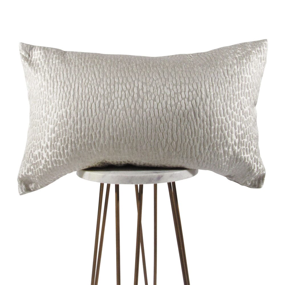 A white, satiny pearl-like textured pillow cover on a pillow stand, with a shiny metallic appearance.