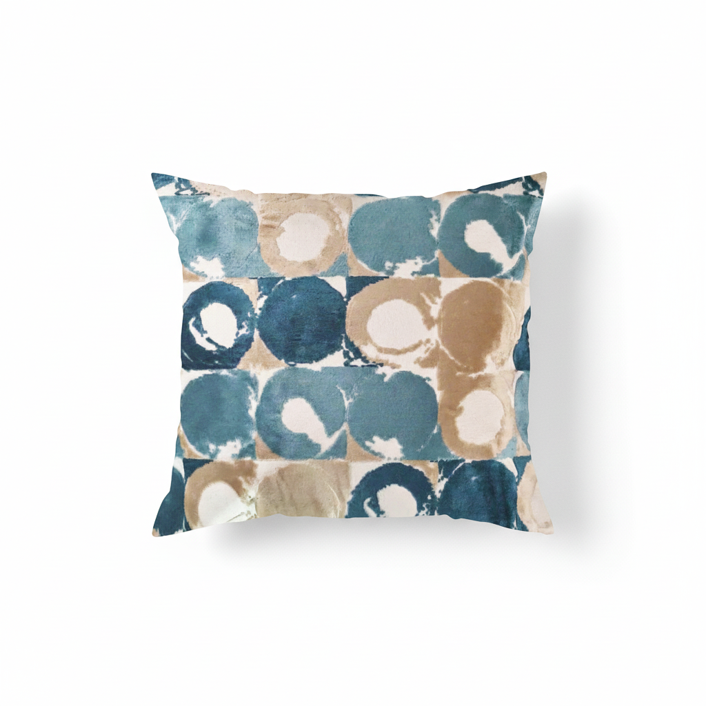 A square-shaped throw pillow with an abstract geometric circle pattern in teal, aqua blue, cream, and tan colors.