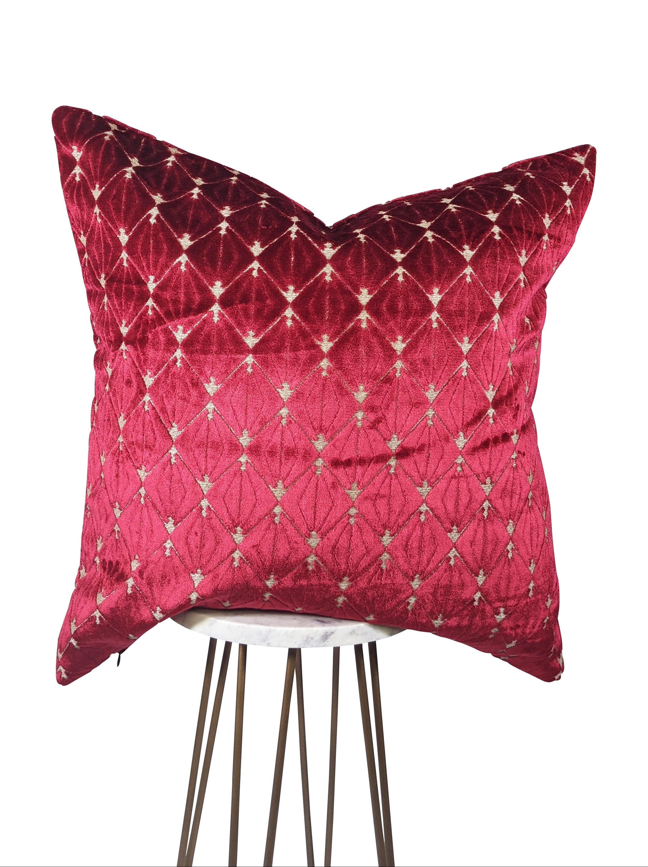 A crimson red velvet pillow with beige diamond-shaped designs, displayed against a white background.