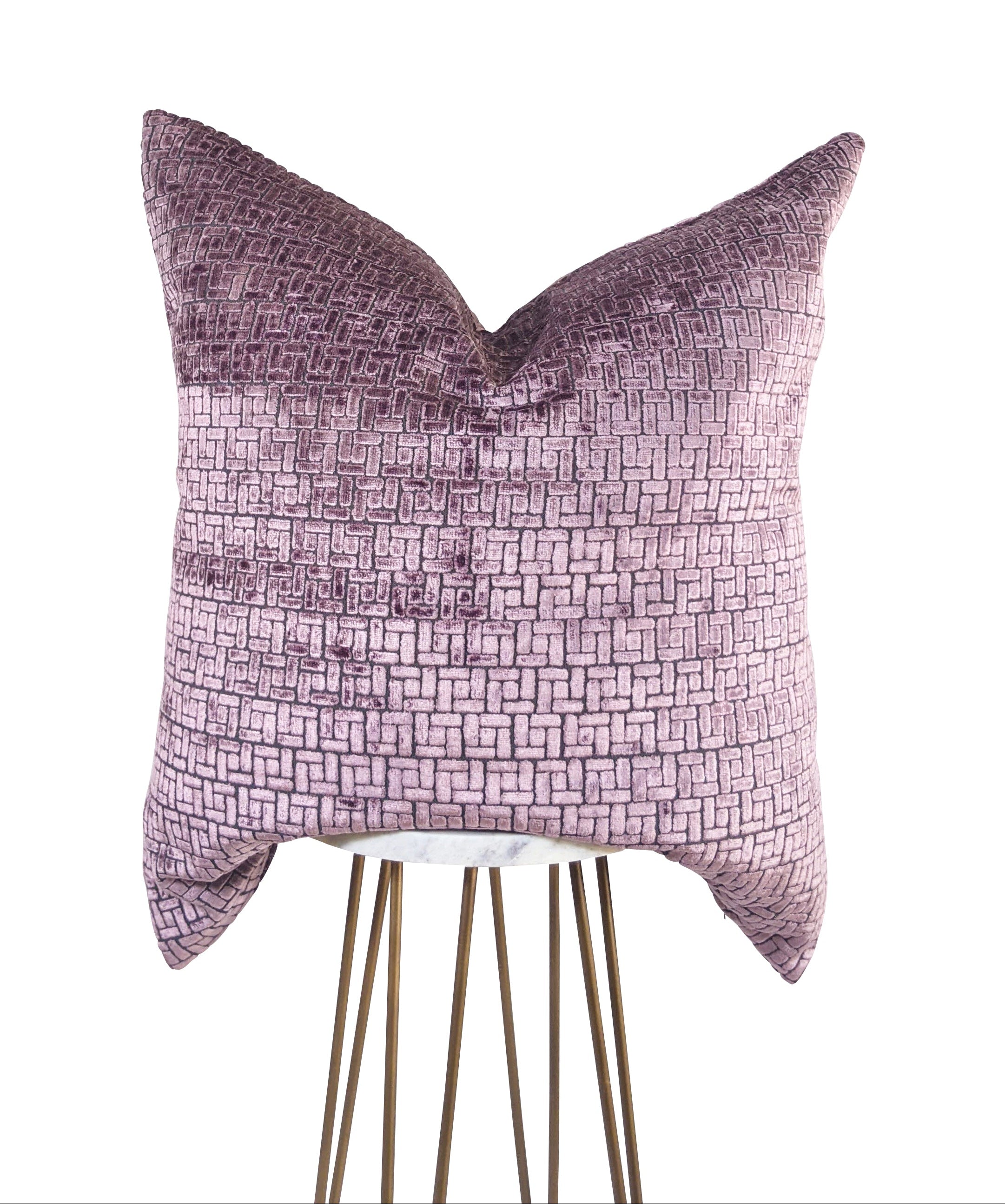 A rectangular-shaped mauve and gray geometric-patterned pillow with a velvet texture, displayed on a stand against a white background.