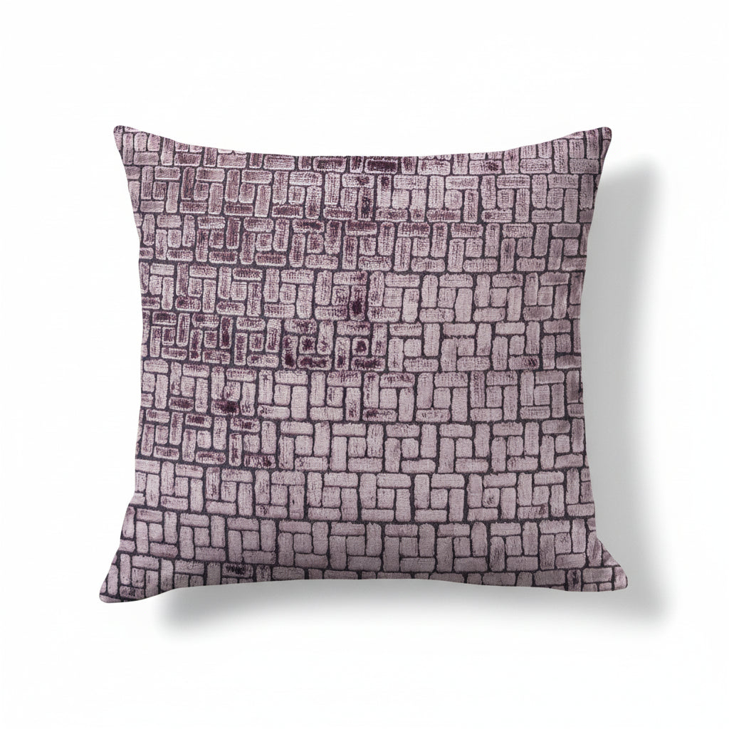 A rectangular throw pillow with a geometric brick pattern in varying shades of gray and purple.