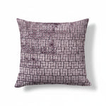 A rectangular throw pillow with a geometric brick pattern in varying shades of gray and purple.