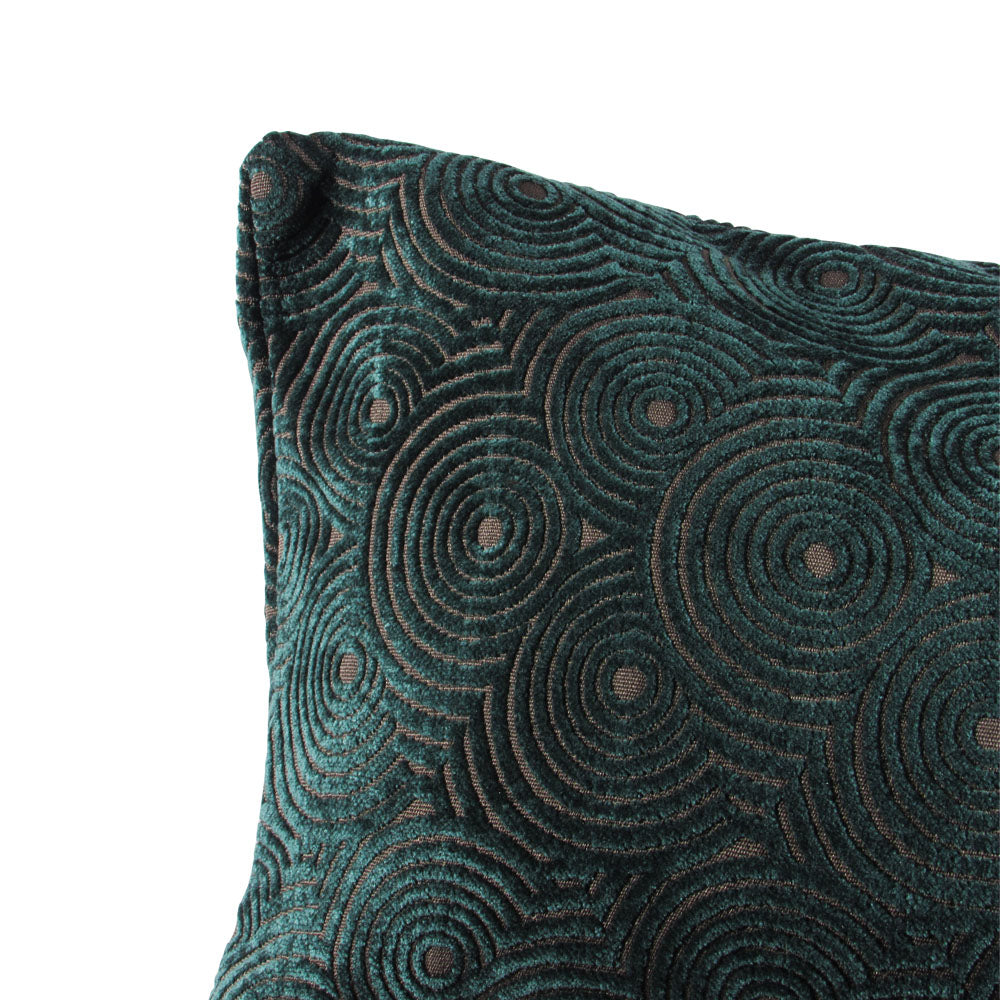 up-close view of a velvet forest green throw pillow with circle designs throughout.