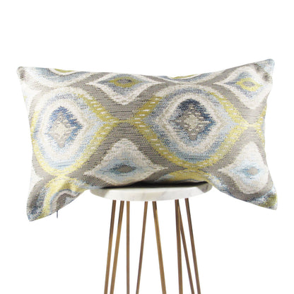 blue, green, gray and white 13x21 throw pillow with big designs, displayed on a small white table.