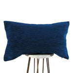 royal blue chenille lumbar pillow displayed on small white circle table