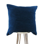 royal blue chenille pillow displayed on small white circle table