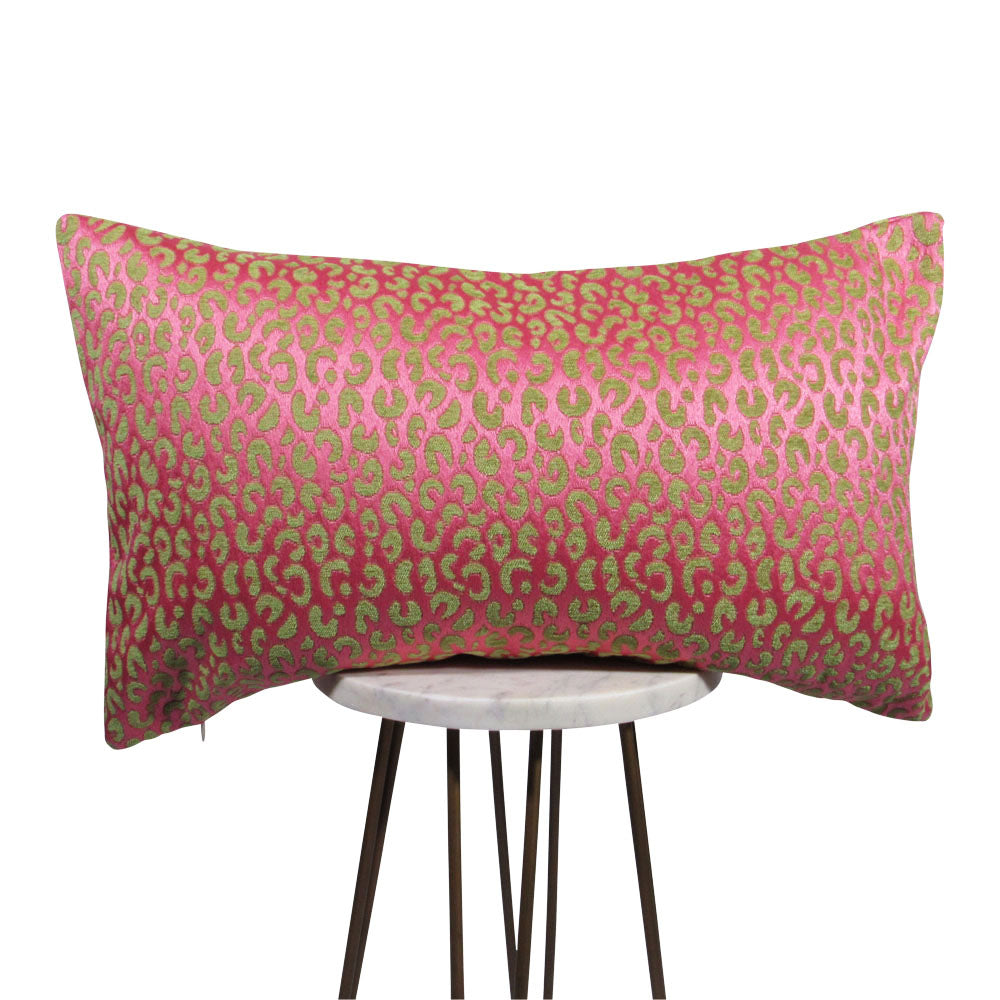 shiny pink and green animal print lumbar pillow on small white table.