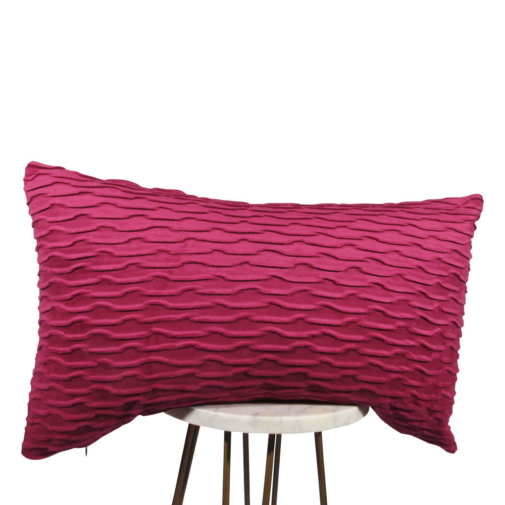 fuchsia 13x21 rectangle throw pillow with wavy indented lines throughout, displayed on small white table.