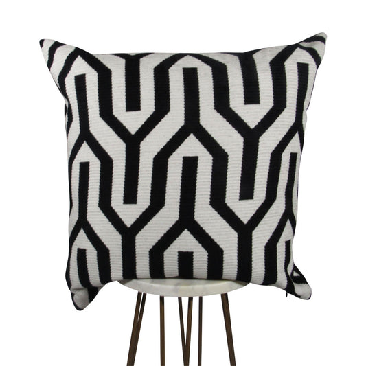 black and white 20x20 square throw pillow with large geometric design throughout, displayed on small white table.