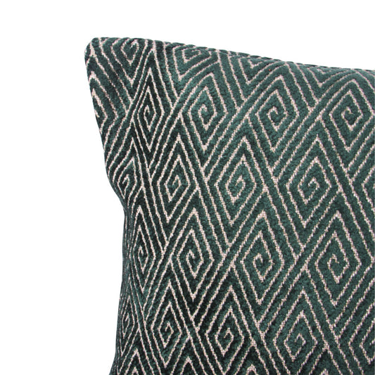 up-close corner view of a forest green and cream throw pillow with geometric shaped design throughout. 