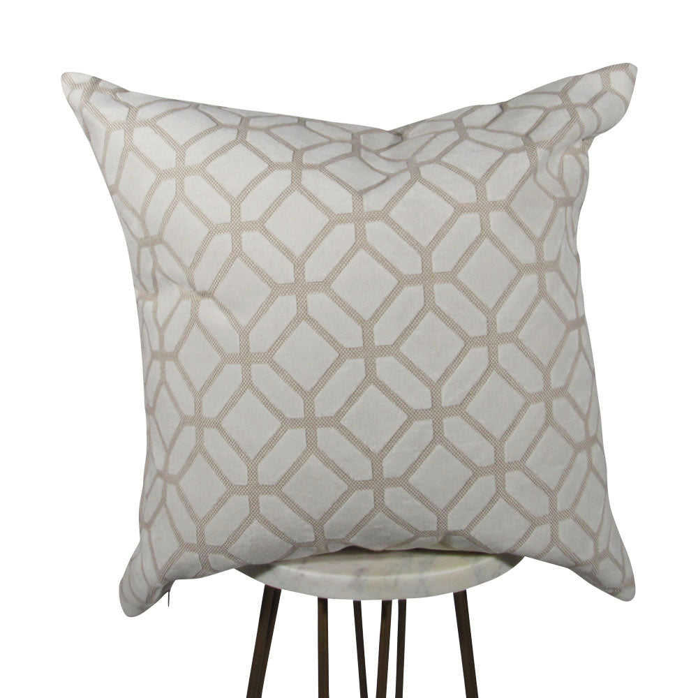 An ivory crushed velvet decorative pillow with a hexagon pattern, displayed on a stand.