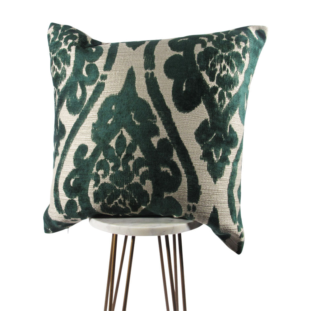 A square-shaped pillow with a grandiose green damask pattern on a creamy background, showcased on a tripod stand.